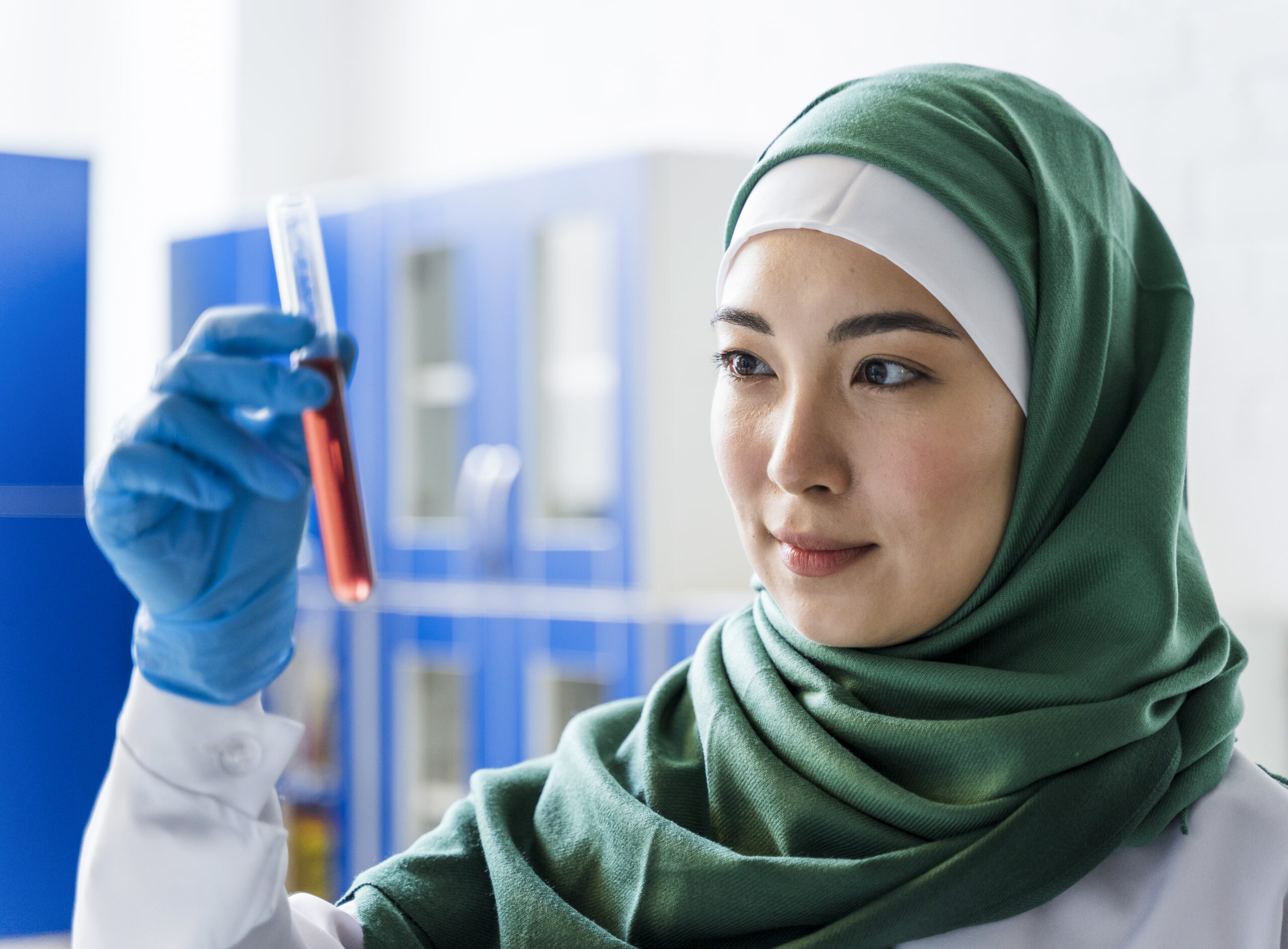 side view female scientist with hijab holding substance
