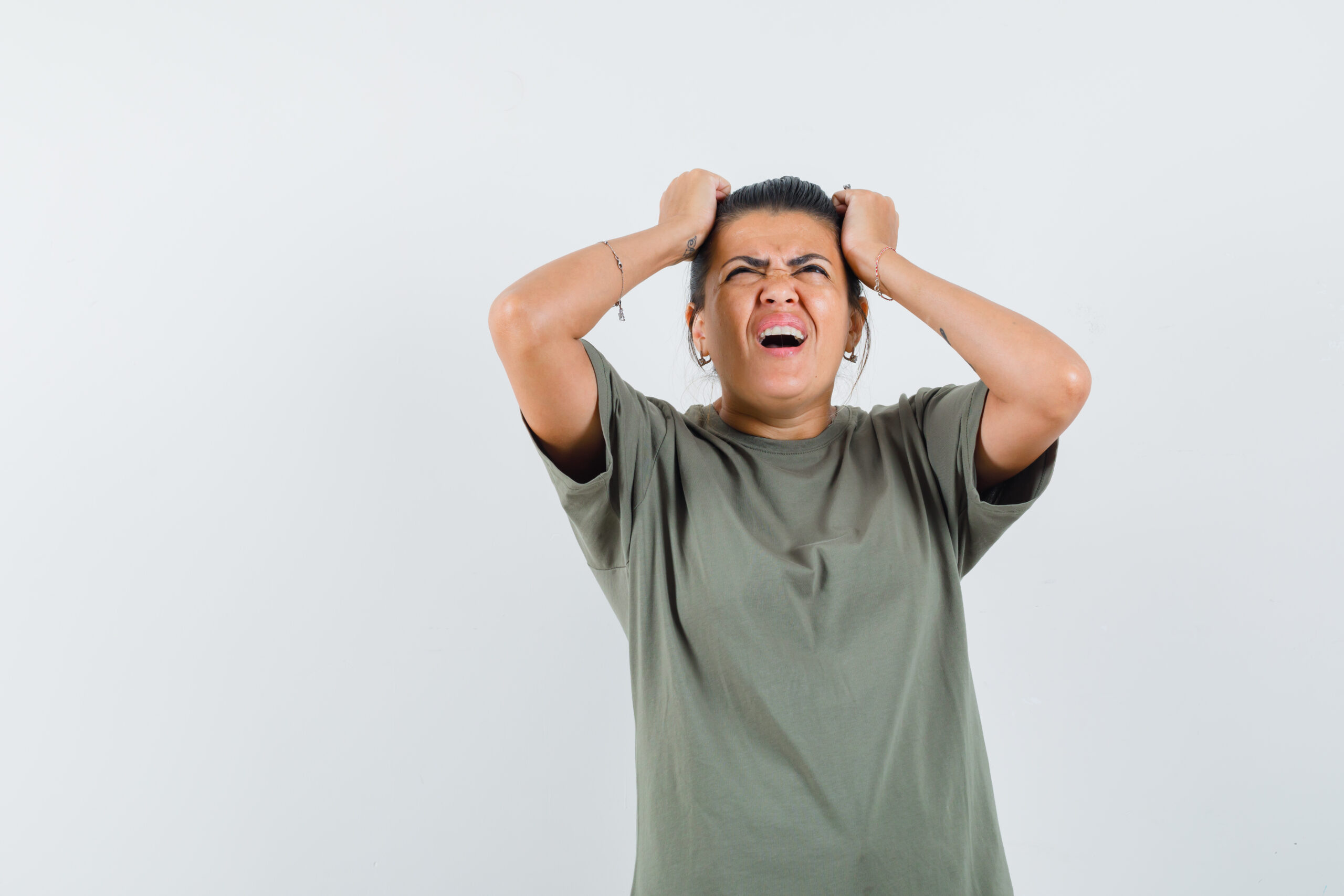 lady holding hands on head in t shirt and looking forgetful , front view.
